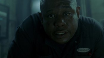 Movie still from “Panic Room” (2002), directed by David Fincher – A man's face in a dark room; Close Up shot, Low angle