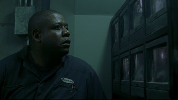 Movie still from “Panic Room” (2002), directed by David Fincher – A man in a black shirt is looking up; Close Up shot, Low angle
