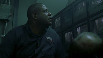 Movie still from “Panic Room” (2002), directed by David Fincher – A man looking up in a dark room; Close Up shot, Low angle