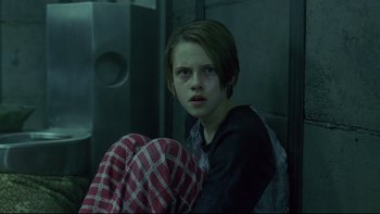 Movie still from “Panic Room” (2002), directed by David Fincher – A young girl sitting on the ground in a room; Medium shot, Low angle