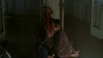 Movie still from “Panic Room” (2002), directed by David Fincher – A man sitting next to a little girl with blood all over his face; Medium shot, High angle