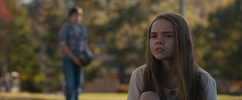 Movie still from “Paper Towns” (2015), directed by Jake Schreier – A young woman sitting on the ground in front of a man; Close Up shot, Over the shoulder angle