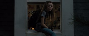 Movie still from “Paper Towns” (2015), directed by Jake Schreier – A girl sitting on a window ledge with a backpack; Medium shot, High angle