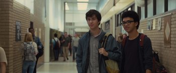 Movie still from “Paper Towns” (2015), directed by Jake Schreier – A young man is walking down a hallway with a backpack; Medium shot, Over the shoulder angle