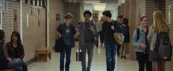 Movie still from “Paper Towns” (2015), directed by Jake Schreier – A group of young men walking down a hallway; Medium shot, Over the shoulder angle