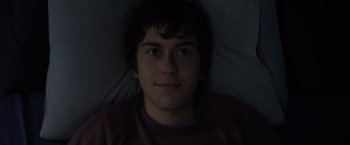Movie still from “Paper Towns” (2015), directed by Jake Schreier – A young man laying in a bed looking up at the camera; Close Up shot, Overhead angle