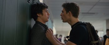 Movie still from “Paper Towns” (2015), directed by Jake Schreier – Two young men standing next to each other in a hallway; Medium shot, Over the shoulder angle
