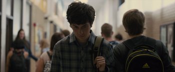 Movie still from “Paper Towns” (2015), directed by Jake Schreier – A young man is walking down a busy hallway; Close Up shot, Over the shoulder angle