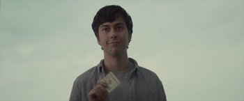 Movie still from “Paper Towns” (2015), directed by Jake Schreier – A young man holding a dollar bill in his hand; Close Up shot, Low angle