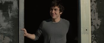 Movie still from “Paper Towns” (2015), directed by Jake Schreier – A man in a gray shirt is smiling and holding his hand out; Medium shot, Over the shoulder angle