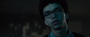 Movie still from “Paper Towns” (2015), directed by Jake Schreier – A young man wearing glasses looking at the camera; Close Up shot, Low angle