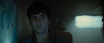 Movie still from “Paper Towns” (2015), directed by Jake Schreier – A young man stares into the distance in a dark room; Close Up shot, Low angle