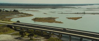 Movie still from “Paper Towns” (2015), directed by Jake Schreier – A train traveling on a bridge over a river; Extreme Wide shot, High angle