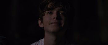 Movie still from “Paper Towns” (2015), directed by Jake Schreier – A young man is smiling for the camera in the dark; Close Up shot, Low angle