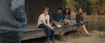 Movie still from “Paper Towns” (2015), directed by Jake Schreier – A group of young people sitting on top of a wooden bench; Medium shot, Low angle