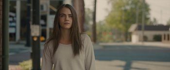 Movie still from “Paper Towns” (2015), directed by Jake Schreier – A woman with long brown hair standing on the sidewalk; Close Up shot, Over the shoulder angle