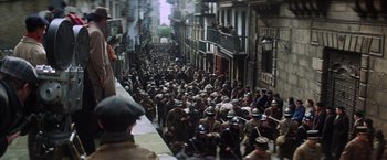 Movie still from “Papillon” (1973), directed by Franklin J. Schaffner – A crowd of people walking down a street; Extreme Wide shot, High angle