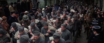 Movie still from “Papillon” (1973), directed by Franklin J. Schaffner – A large group of men in grey clothes and black hats; Wide shot, High angle