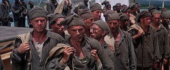 Movie still from “Papillon” (1973), directed by Franklin J. Schaffner – A group of men standing next to each other; Medium shot, High angle