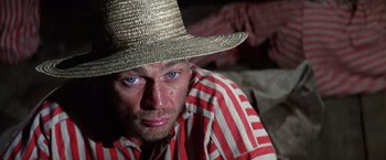 Movie still from “Papillon” (1973), directed by Franklin J. Schaffner – A person wearing a straw hat; Close Up shot, Low angle