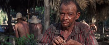 Movie still from “Papillon” (1973), directed by Franklin J. Schaffner – An old man is holding something in his hand; Close Up shot, Over the shoulder angle