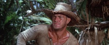 Movie still from “Papillon” (1973), directed by Franklin J. Schaffner – A person wearing a straw hat; Close Up shot, Low angle