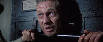 Movie still from “Papillon” (1973), directed by Franklin J. Schaffner – An older man with a beard and blue eyes; Close Up shot, Low angle