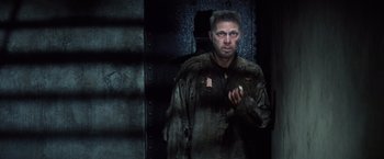Movie still from “Papillon” (1973), directed by Franklin J. Schaffner – A man standing in the dark wearing a jacket; Medium shot, Low angle