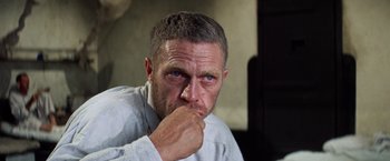 Movie still from “Papillon” (1973), directed by Franklin J. Schaffner – A person with his hand to his face; Close Up shot, Low angle
