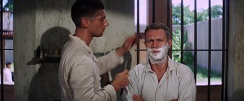 Movie still from “Papillon” (1973), directed by Franklin J. Schaffner – A man shaving another man's face with a razor; Close Up shot, Over the shoulder angle