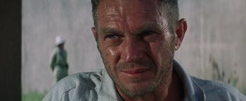 Movie still from “Papillon” (1973), directed by Franklin J. Schaffner – A man's face with water droplets on his face; Close Up shot, Over the shoulder angle