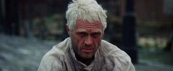 Movie still from “Papillon” (1973), directed by Franklin J. Schaffner – A person with white hair; Close Up shot, Low angle