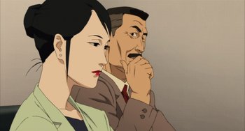 Movie still from “Paprika” (2006), directed by Satoshi Kon – A man and a woman sitting next to each other in front of a wall; Close Up shot, Low angle