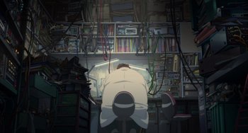 Movie still from “Paprika” (2006), directed by Satoshi Kon – A man sitting in front of a computer monitor; Wide shot, Low angle