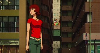 Movie still from “Paprika” (2006), directed by Satoshi Kon – A woman standing in front of a tall building; Wide shot, Low angle