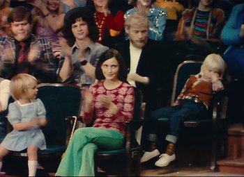Movie still from “Parade” (1974), directed by Jacques Tati – A group of people sitting in a room; Wide shot, High angle