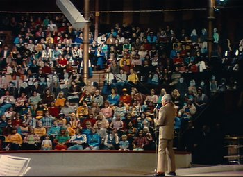 Movie still from “Parade” (1974), directed by Jacques Tati – A man standing in front of a crowd of people; Extreme Wide shot, High angle