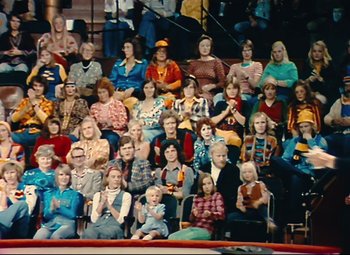 Movie still from “Parade” (1974), directed by Jacques Tati – A crowd of people sitting in a stadium; Wide shot, High angle