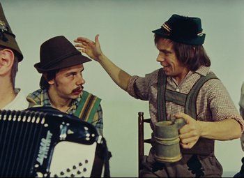 Movie still from “Parade” (1974), directed by Jacques Tati – Two men are dressed in traditional bavarian clothing; Medium shot, Low angle