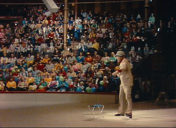 Movie still from “Parade” (1974), directed by Jacques Tati – A man standing in front of an audience in front of a crowd; Extreme Wide shot, High angle