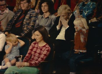 Movie still from “Parade” (1974), directed by Jacques Tati – A group of people sitting in a room; Medium shot, High angle