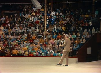 Movie still from “Parade” (1974), directed by Jacques Tati – A man standing in front of a crowd of people; Extreme Wide shot, High angle