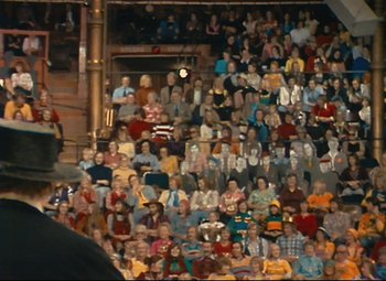 Movie still from “Parade” (1974), directed by Jacques Tati – A large group of people sitting in a stadium; Wide shot, High angle