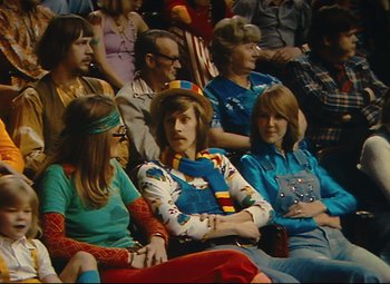 Movie still from “Parade” (1974), directed by Jacques Tati – A group of people sitting in a room; Medium shot, High angle