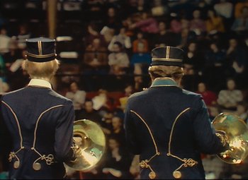 Movie still from “Parade” (1974), directed by Jacques Tati – Two men in blue jackets and hats standing in front of a crowd; Medium shot, High angle
