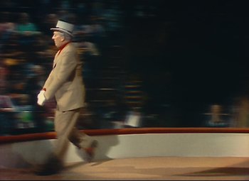Movie still from “Parade” (1974), directed by Jacques Tati – A man in a suit and hat walking on a stage; Wide shot, High angle