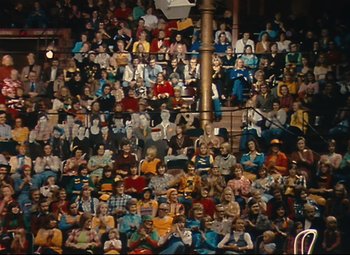 Movie still from “Parade” (1974), directed by Jacques Tati – A crowd of people sitting in the stands at a sporting event; Extreme Wide shot, High angle