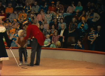 Movie still from “Parade” (1974), directed by Jacques Tati – A man and a boy are standing in front of an audience; Wide shot, High angle