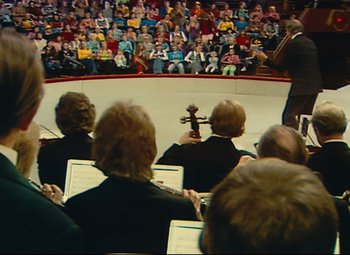 Movie still from “Parade” (1974), directed by Jacques Tati – A group of people sitting in front of an audience; Extreme Wide shot, High angle