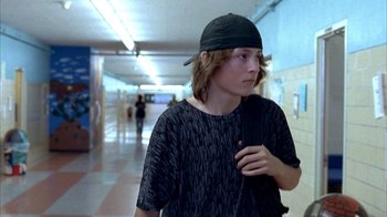 Movie still from “Paranoid Park” (2007), directed by Gus Van Sant – A young man with a backpack walking down a hall way; Medium shot, Low angle
